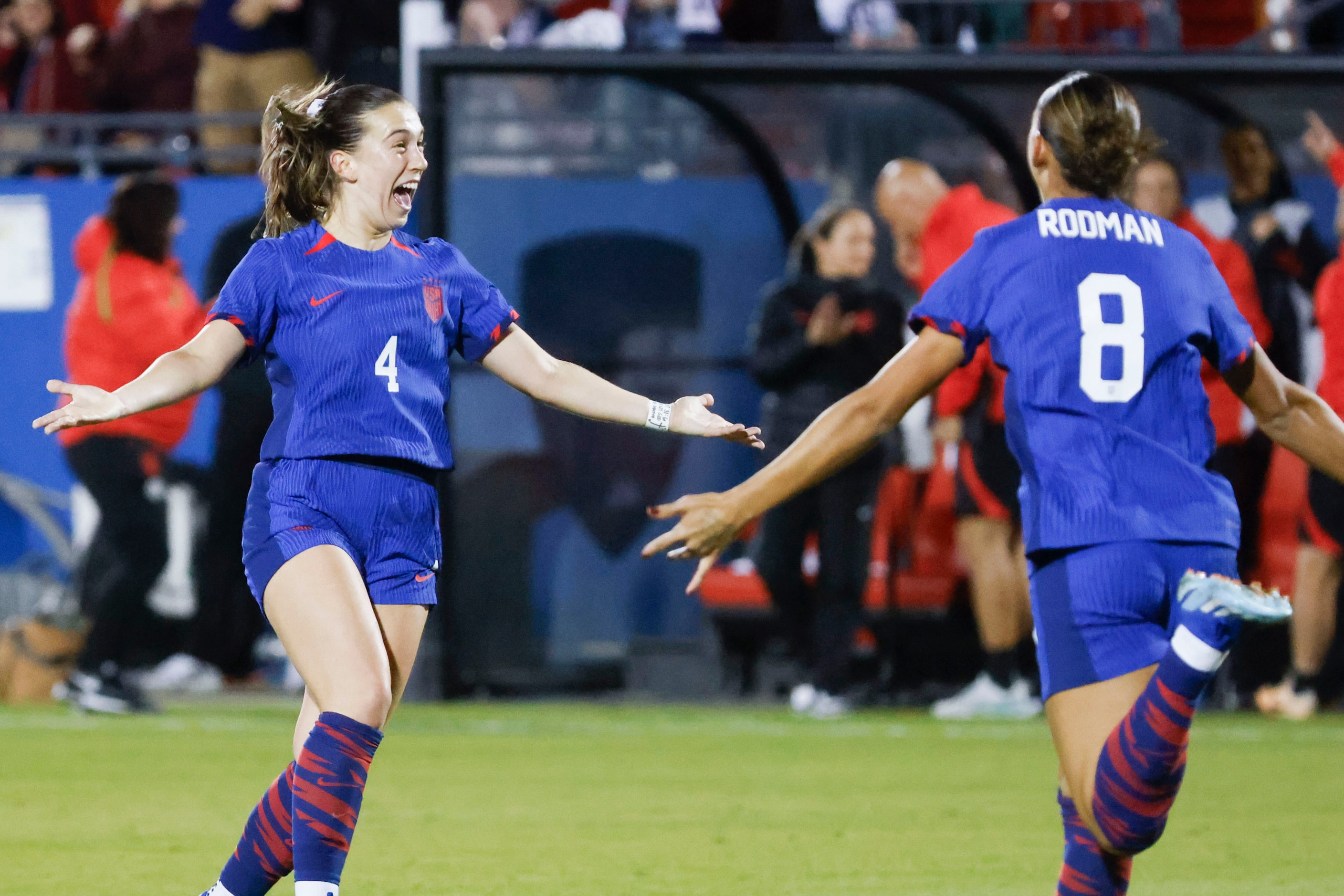 United States midfielder Sam Coffey (left) celebrates a goal with forward Trinity Rodman...