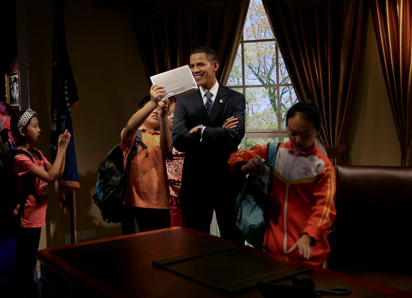  A Chinese student uses a tablet to take selfie with a wax figure of President Barack Obama...