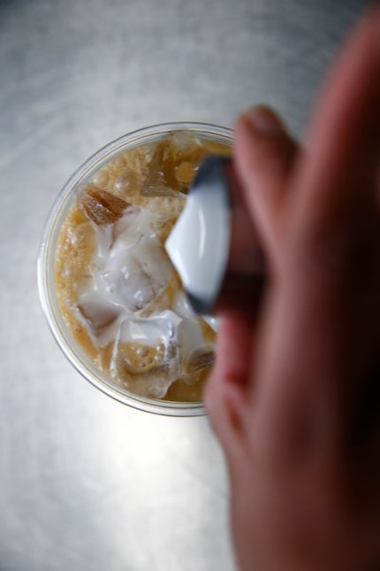 Coconut milk is poured into coffee at Sandwich Hag in Dallas.