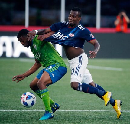 Seattle Sounders' Jordan McCrary, left, and New England Revolution's Cristian Penilla battle...