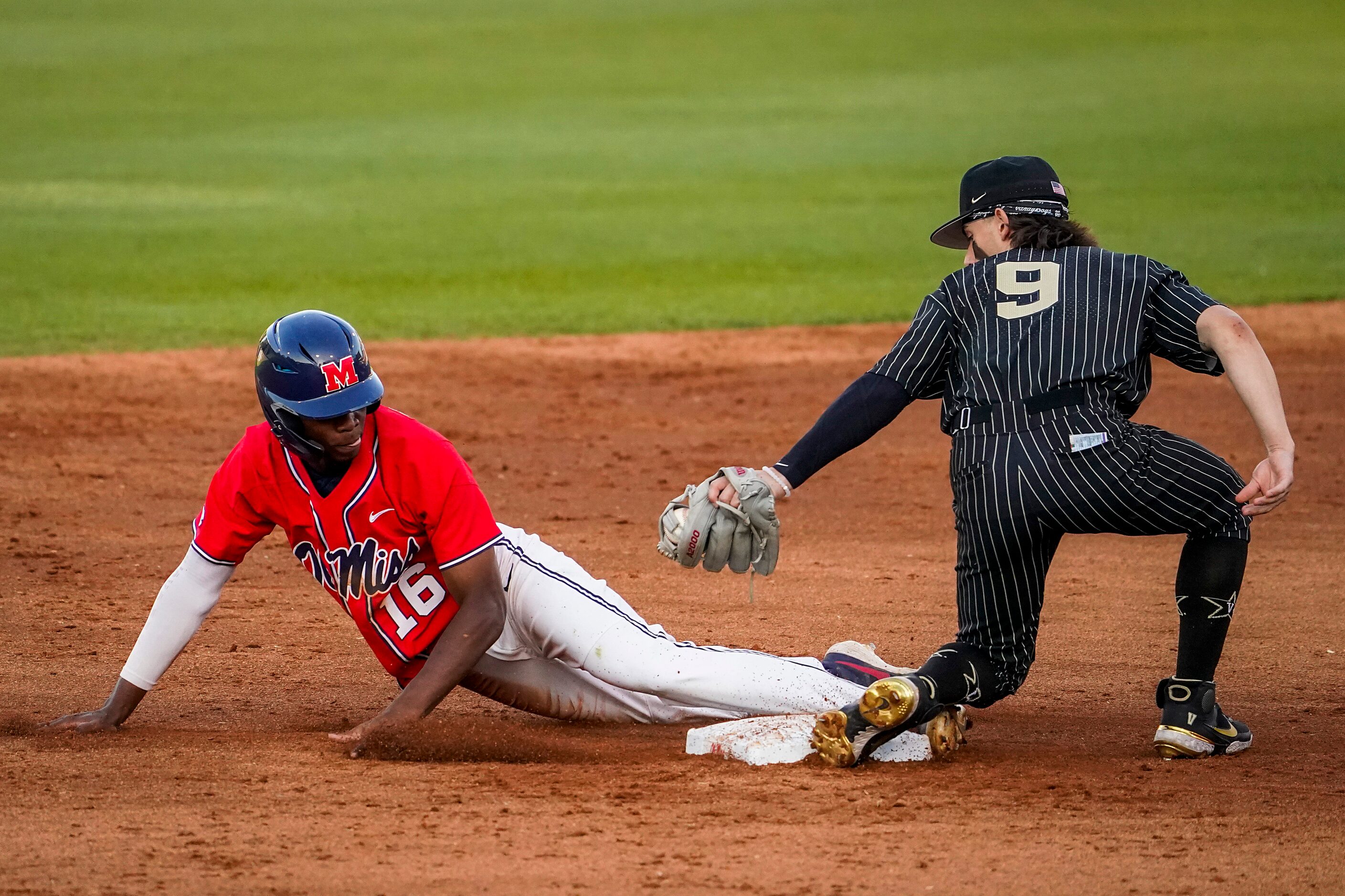 Mississippi center fielder TJ McCants gets past the tag of Vanderbilt infielder Carter Young...