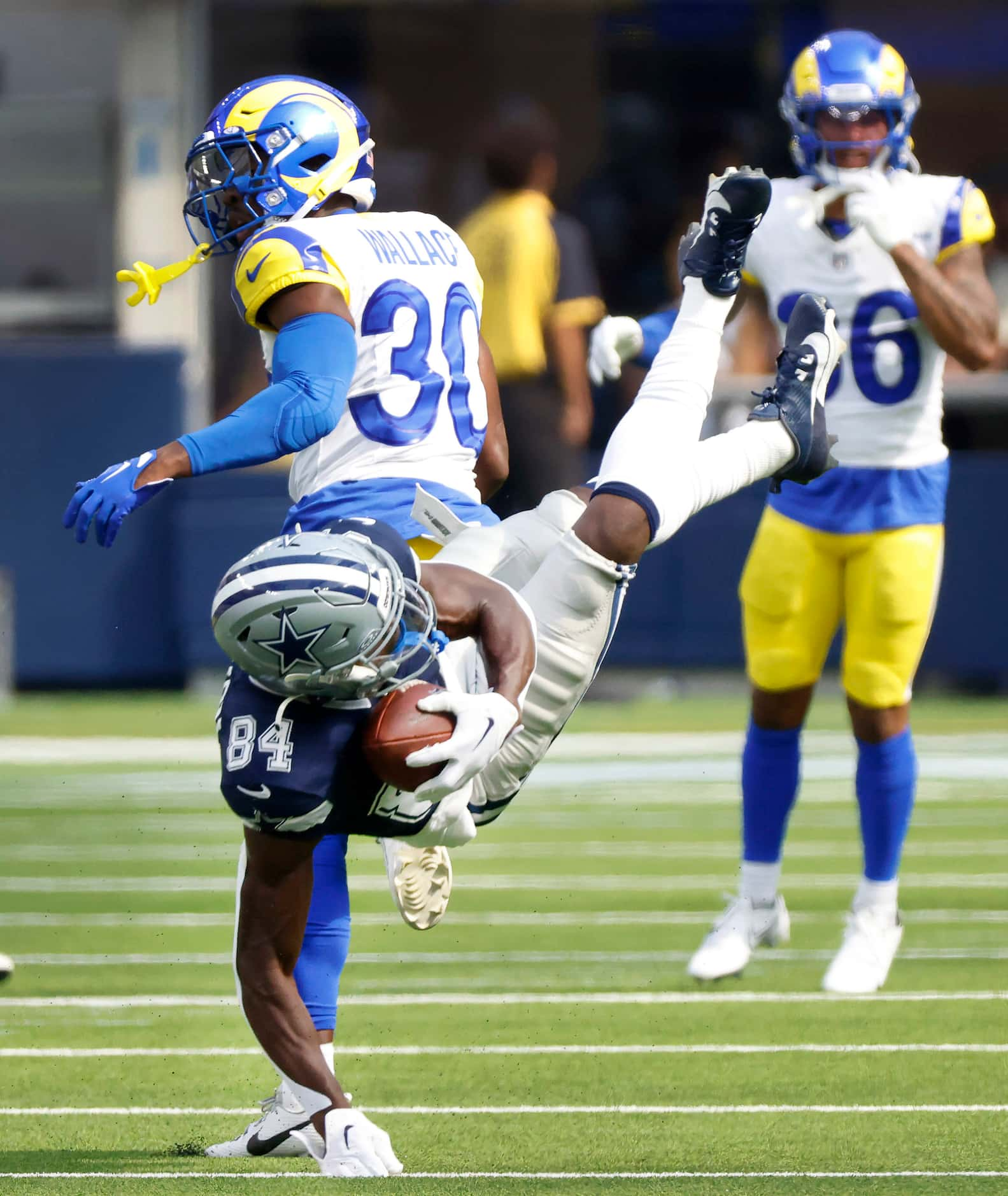 Dallas Cowboys wide receiver Kelvin Harmon (84) is upended by Los Angeles Rams cornerback...