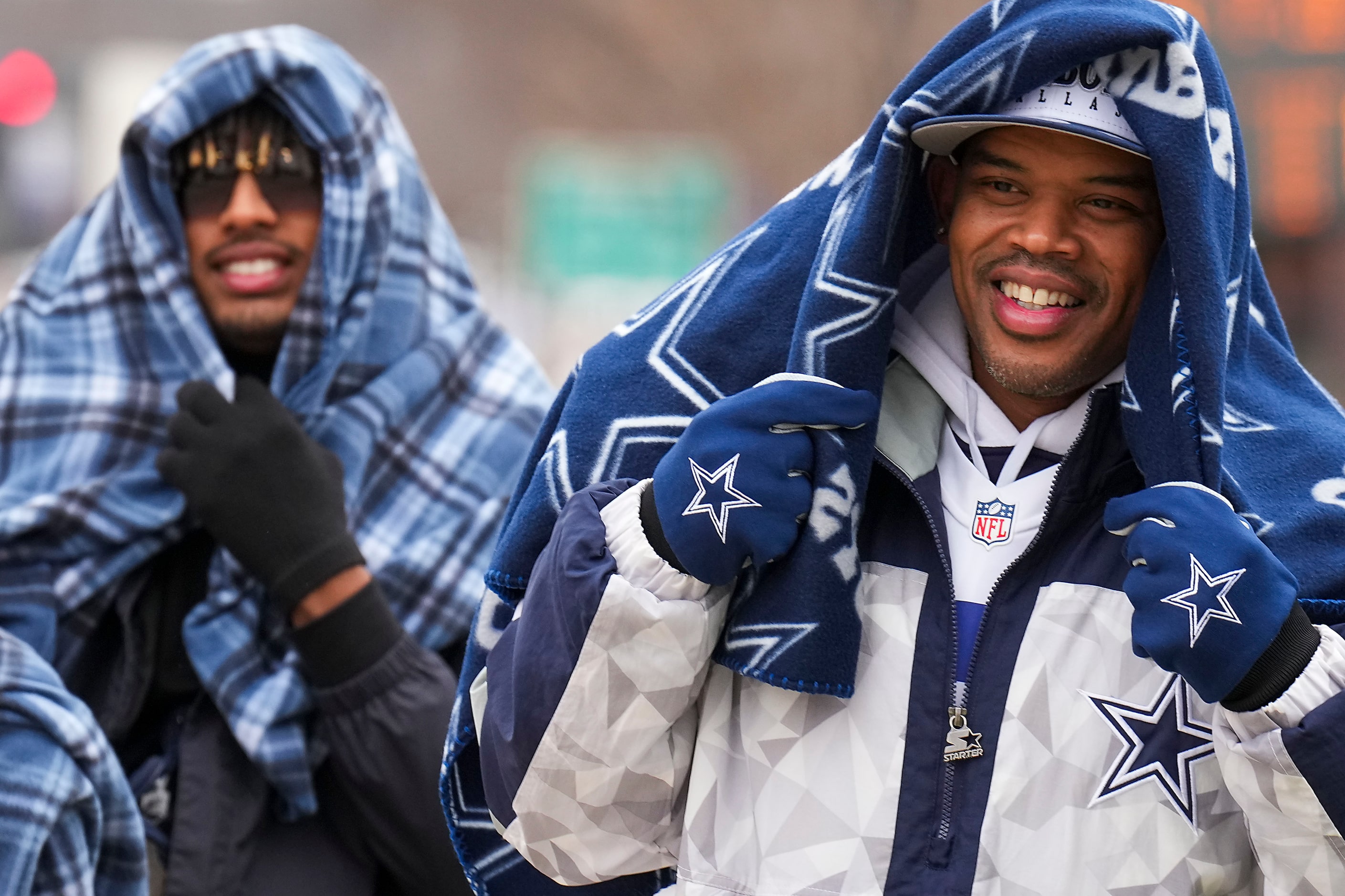 Dallas Cowboys fans Luke Ortiz (right) and 
Mekhi Armstead bundle up on their way into the...