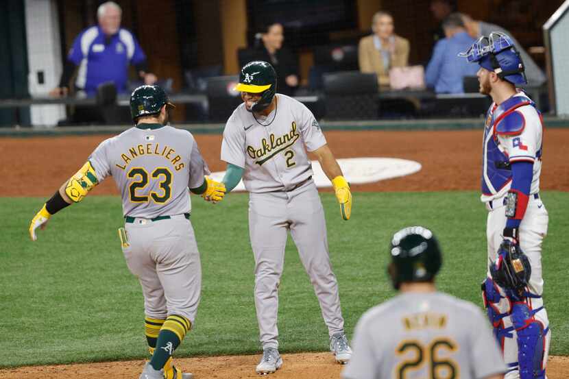 Oakland Athletics catcher Shea Langeliers (23) gets a high-five from his teammate shortstop...