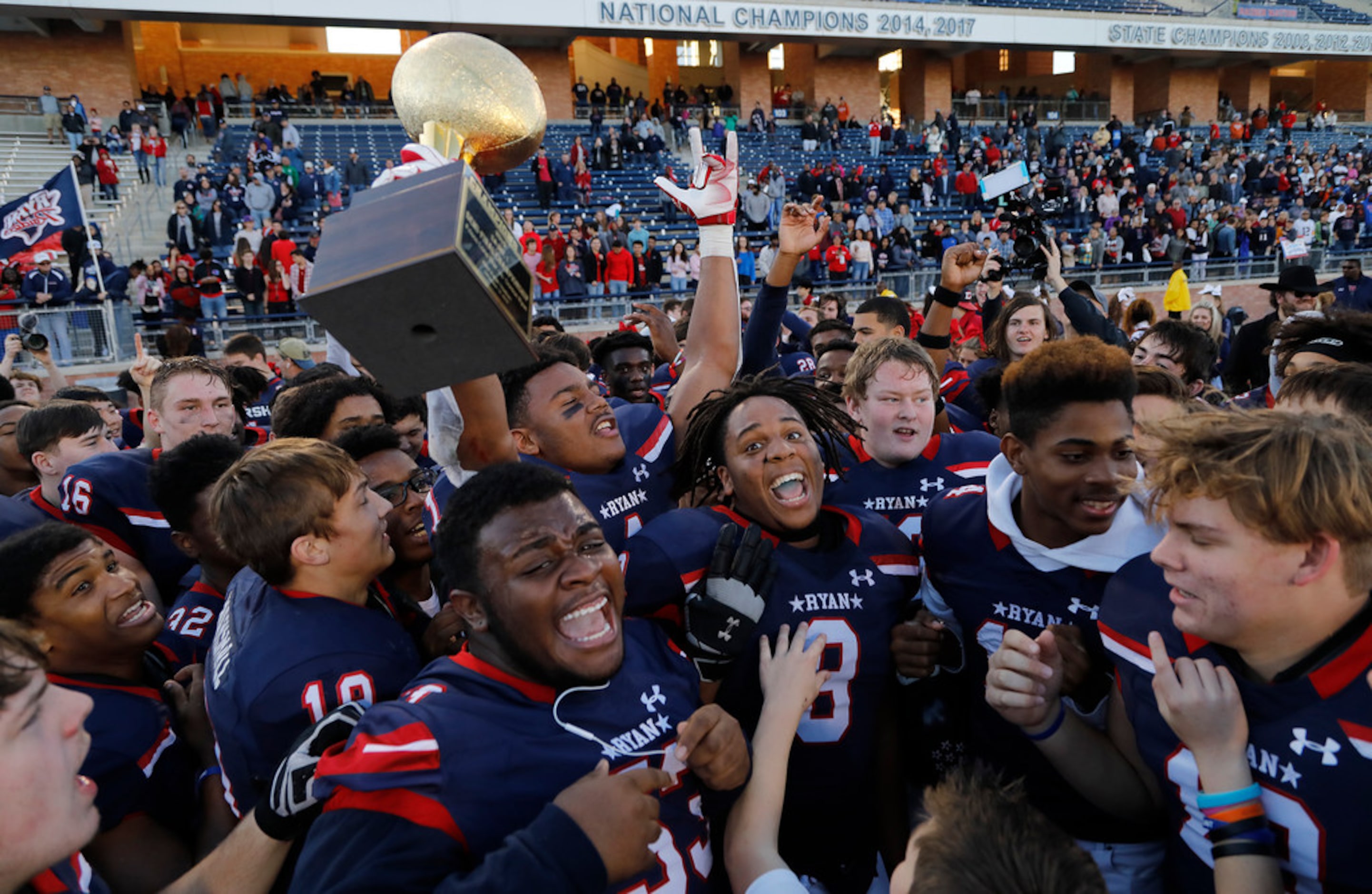 Denton Ryan High School Ja'tavion Sanders (1) holds up the semi-finals championship trophy...