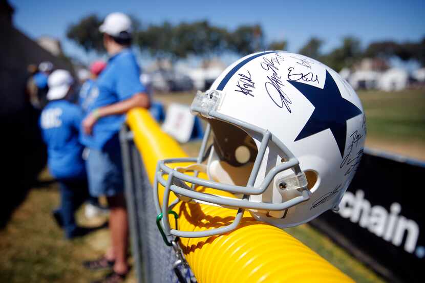 A signed Dallas Cowboys helmet sits along the fence following their last practice of...