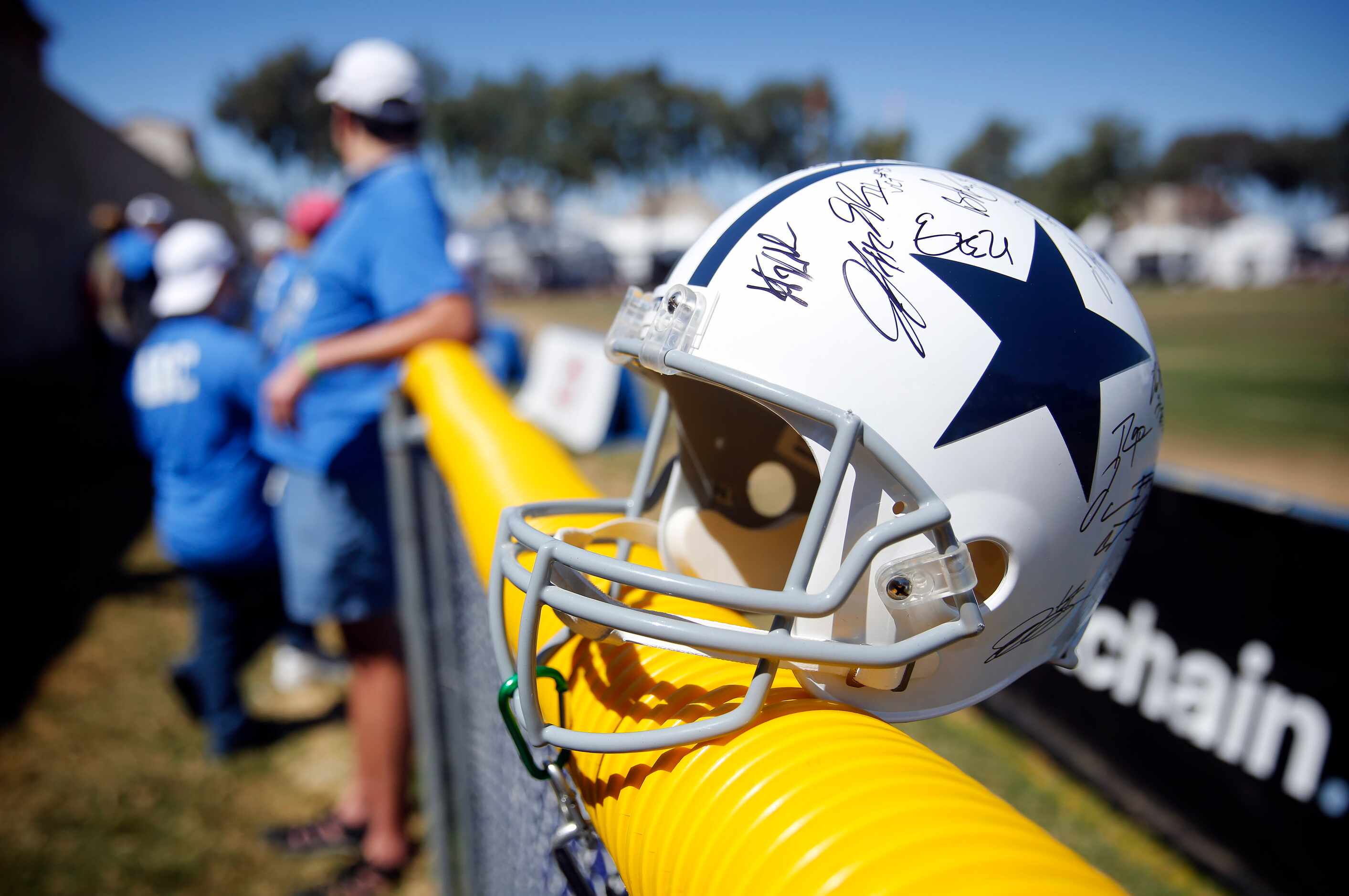 A signed Dallas Cowboys helmet sits along the fence following their last practice of...