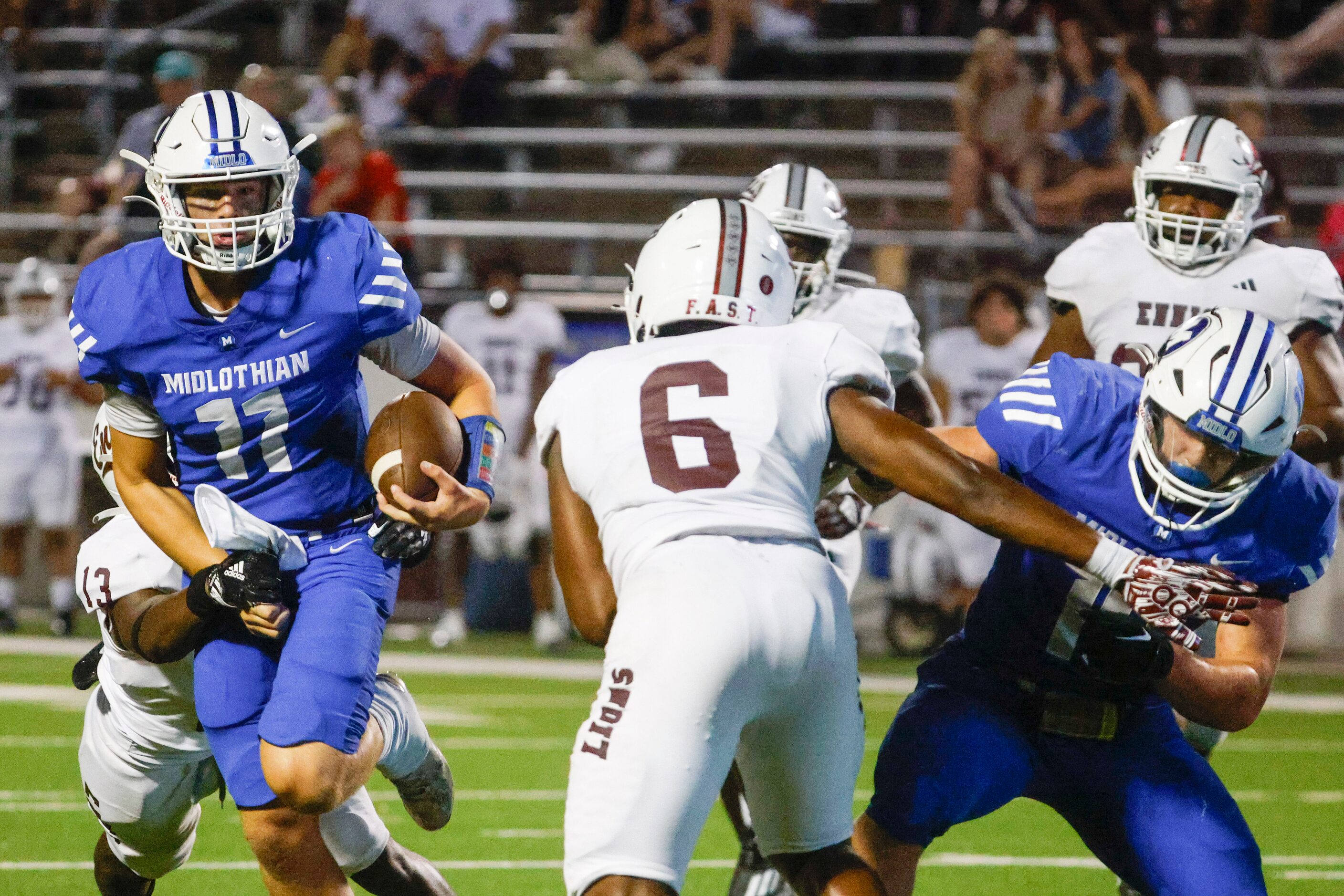 Midlothian high’s QB Drew Wendel (11) runs for a yardage as Ennis high’s Prince Joiner (left...