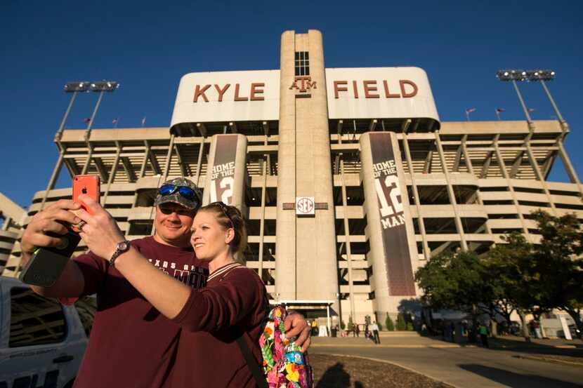 Texas A&M fans Clint and Nicole Ellis, of LaVernia, take a photo of themselves outside the...