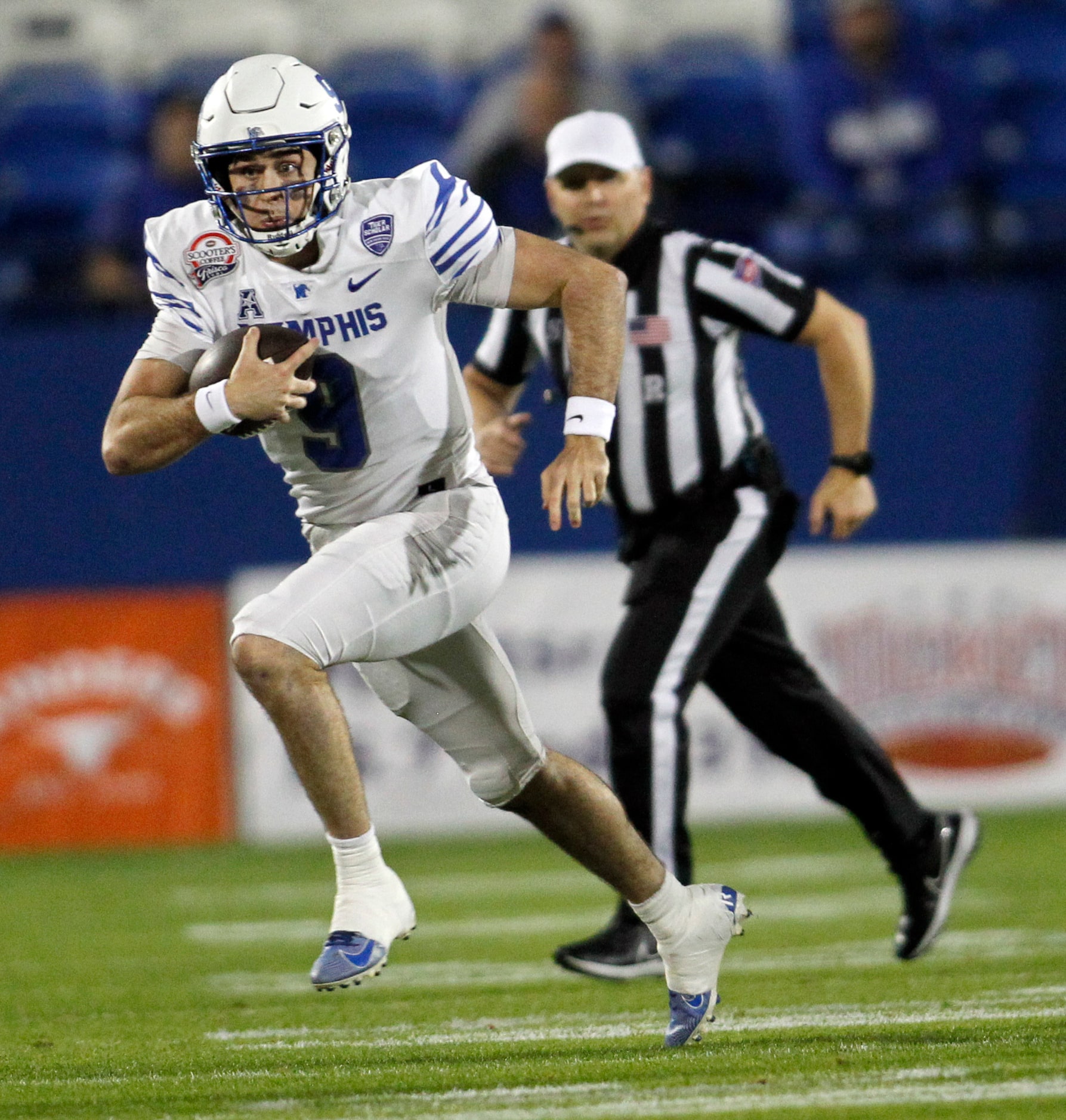 Memphis quarterback Seth Henigan (9) rushes for a first down during second quarter action...