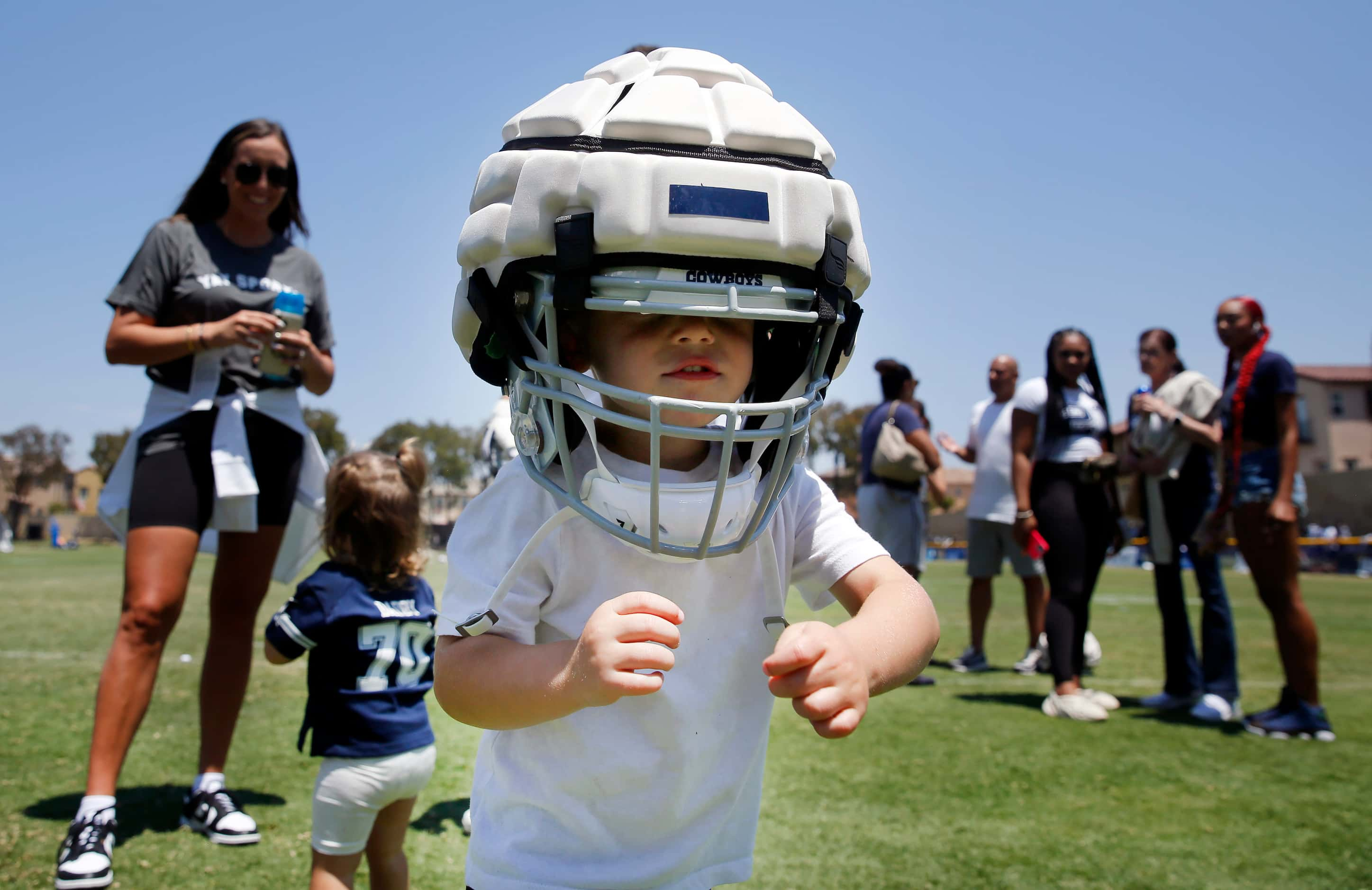 Dallas Cowboys guard Zack Martin’s sin Charlie tries on his Guardian Cap covered football...