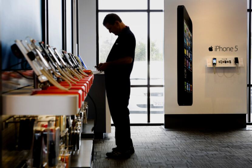 A customer shops for phones at an AT&T store in Manhattan Beach, Calif. AT&T Inc. is joining...