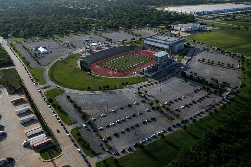 Hundreds of cars weave around the Ellis Davis Field House in Dallas at a COVID-19 test site...