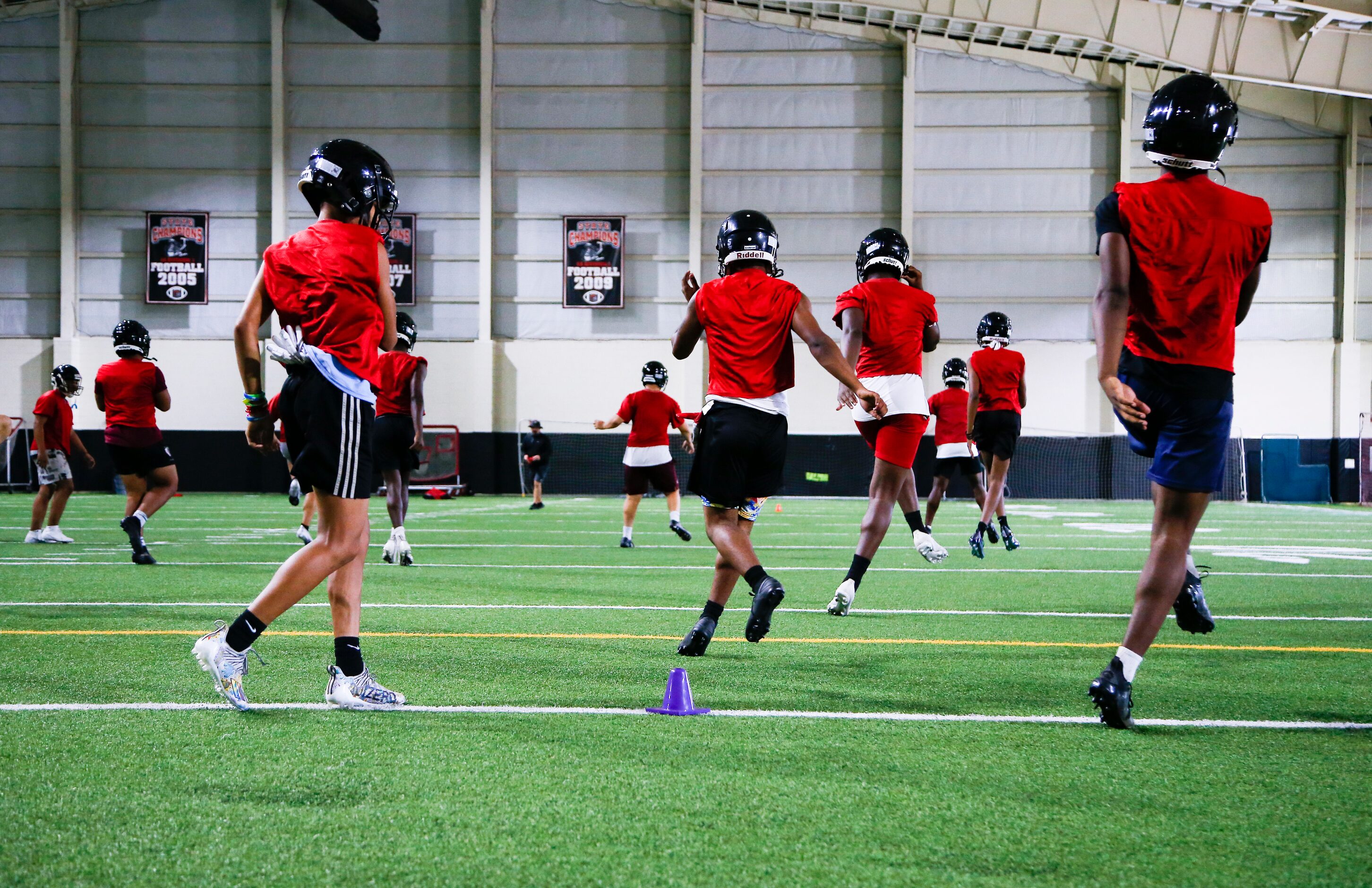 Euless Trinity’s varsity football team runs drills during a practice at Euless Trinity High...