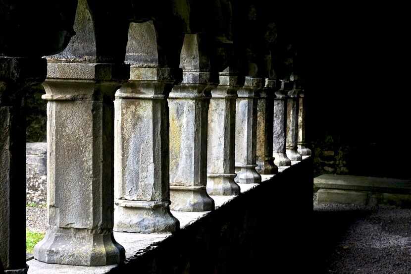 On a cloudy day, light breaks through the courtyard columns at Sligo Abbey, a ruin built in...