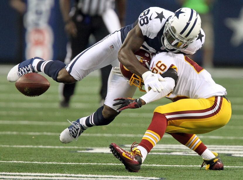Dallas wide receiver Dez Bryant (88) fumbles after catching a pass, on a hit by Washington's...