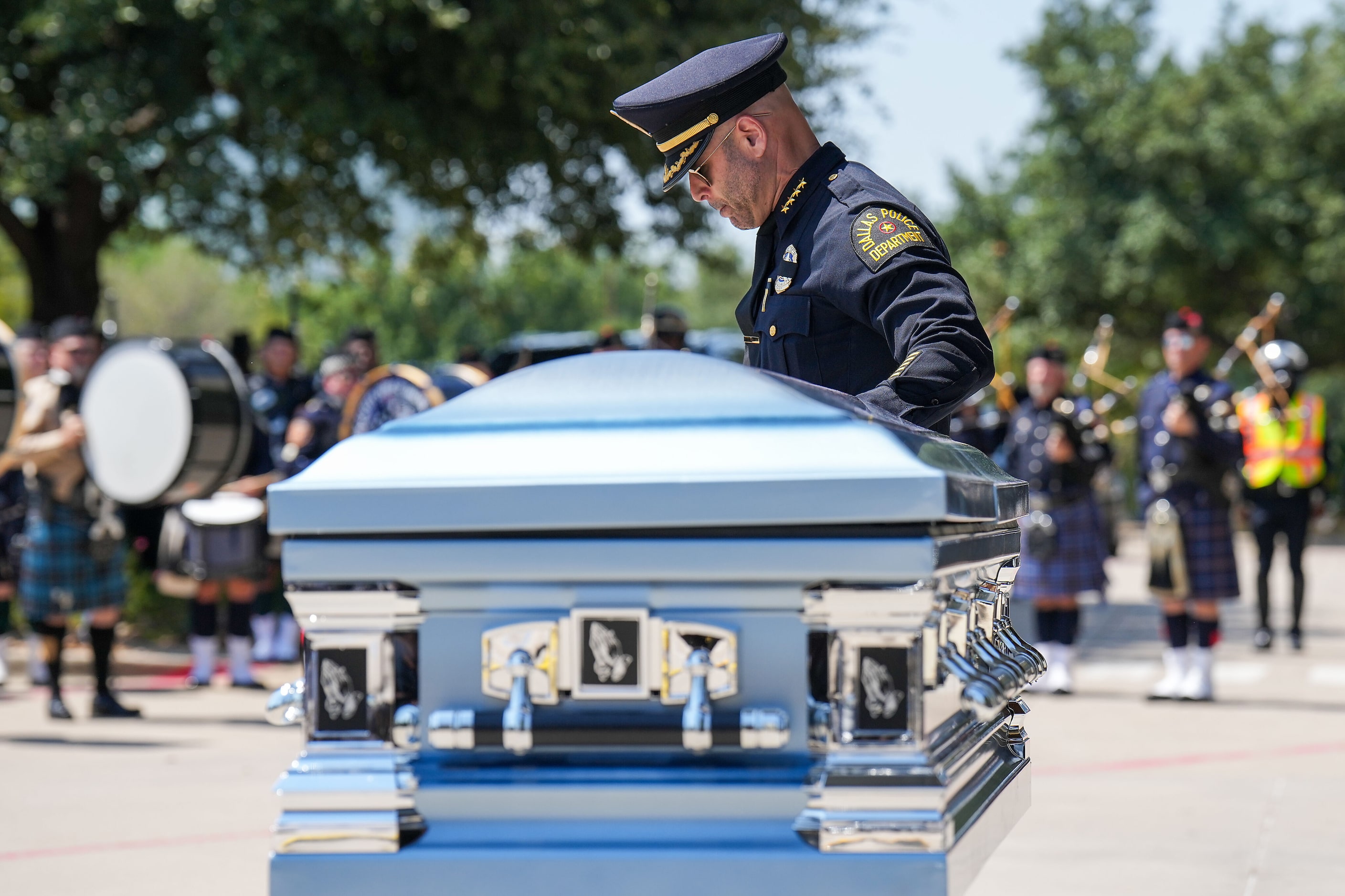 Dallas Police Chief Eddie García touches the casket of officer Darron Burks during honors...