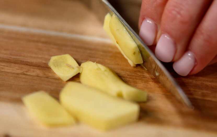 Rebecca White slices ginger while she demonstrates how to make turmeric latte in The Dallas...
