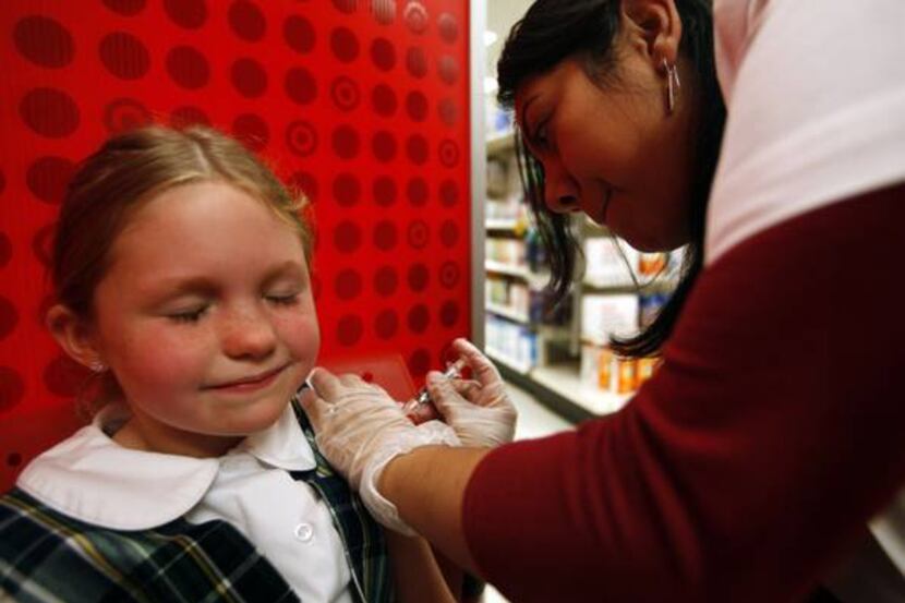Alexis Ekstrom, 8, received a flu shot last week from pharmacist Claudia Torres at a Target...