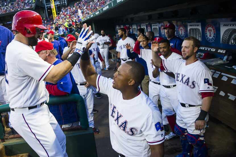 Texas Rangers first baseman Mitch Moreland (left) gets a high five from third baseman Adrian...