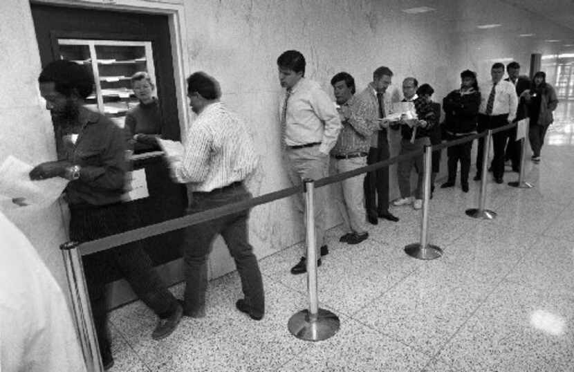 Last-minute tax filers line up at  the IRS window in the lobby of the federal building in...