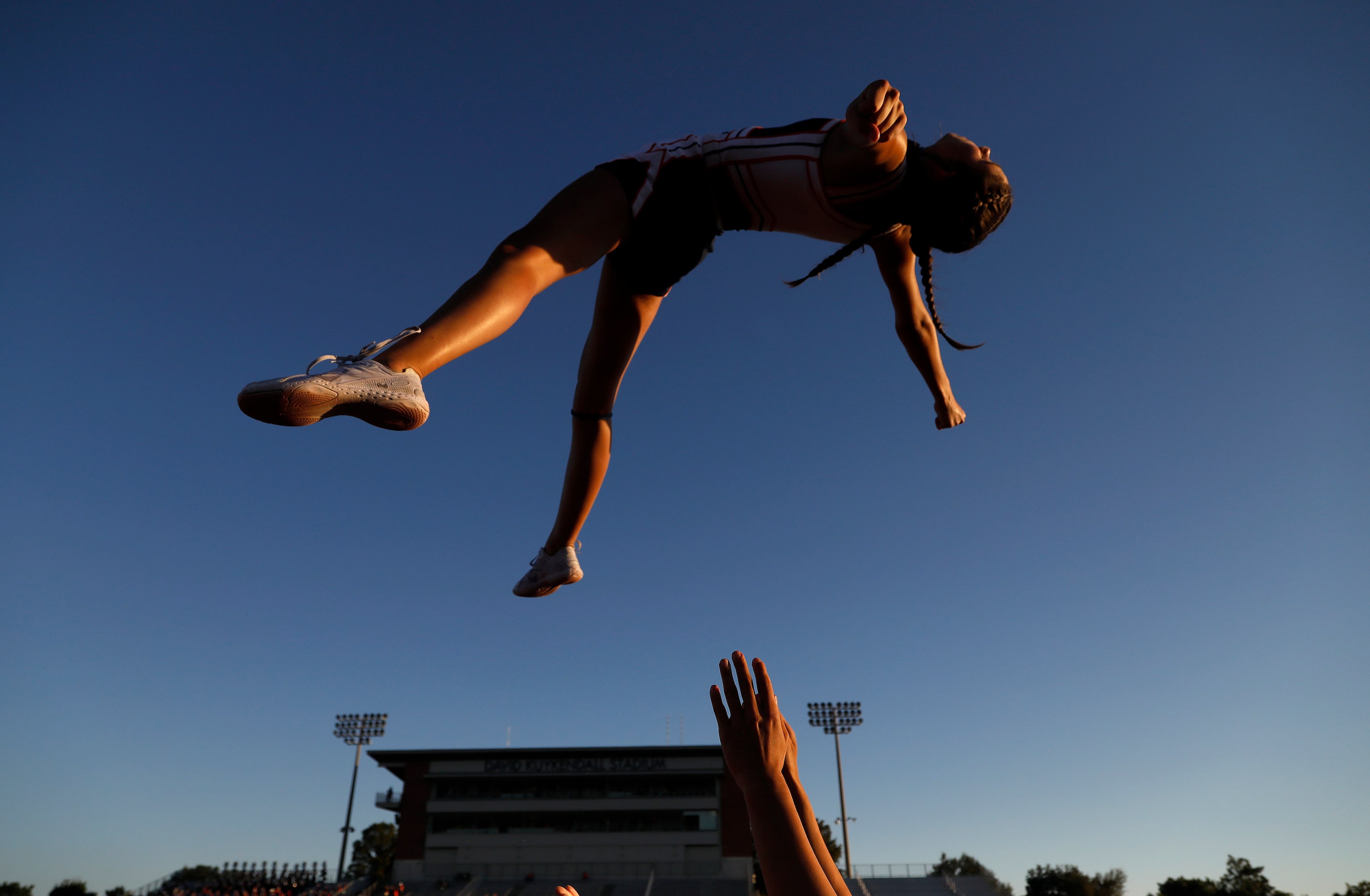 McKinney North High School cheerleader Bella Matthews, 15, is launched into the air by...