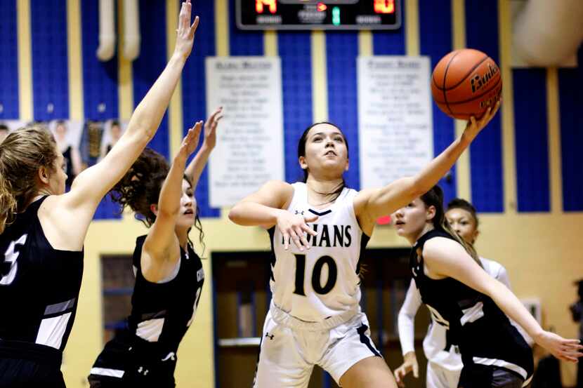 Keller's Emma Taylor (10) puts up a shot between the defense of Denton Guyer defenders, from...