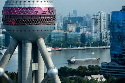 Boats on the Huangpu River pass behind the Oriental Pearl Tower on Tuesday, Oct. 2, 2018, in...