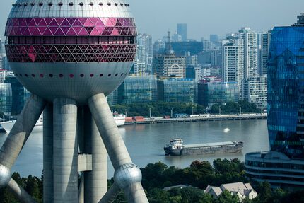 Boats on the Huangpu River pass behind the Oriental Pearl Tower on Tuesday, Oct. 2, 2018, in...