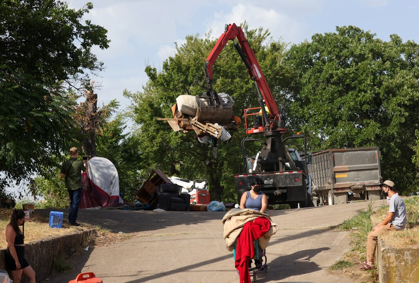 Destiny H. (center) pushes a cart she spotted belonging to someone living in the homeless...