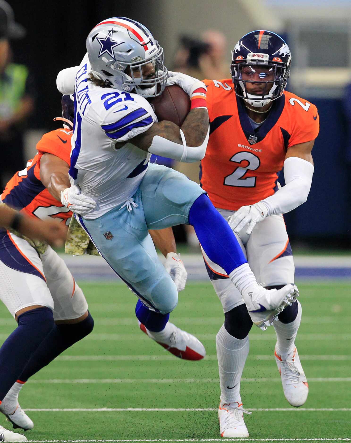 Dallas Cowboys running back Ezekiel Elliott (21) flies through the air, as he runs a first...
