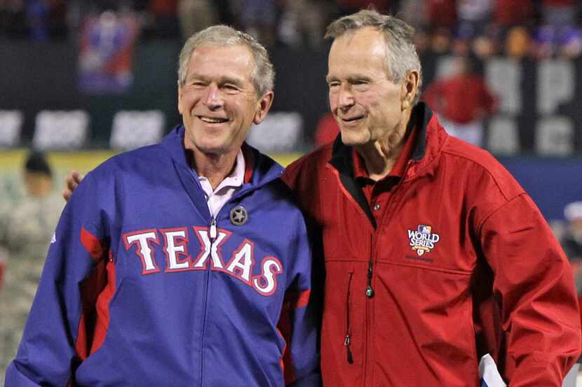 Former Presidents George Bush, right, and his son, George W. Bush are caught by Rangers...