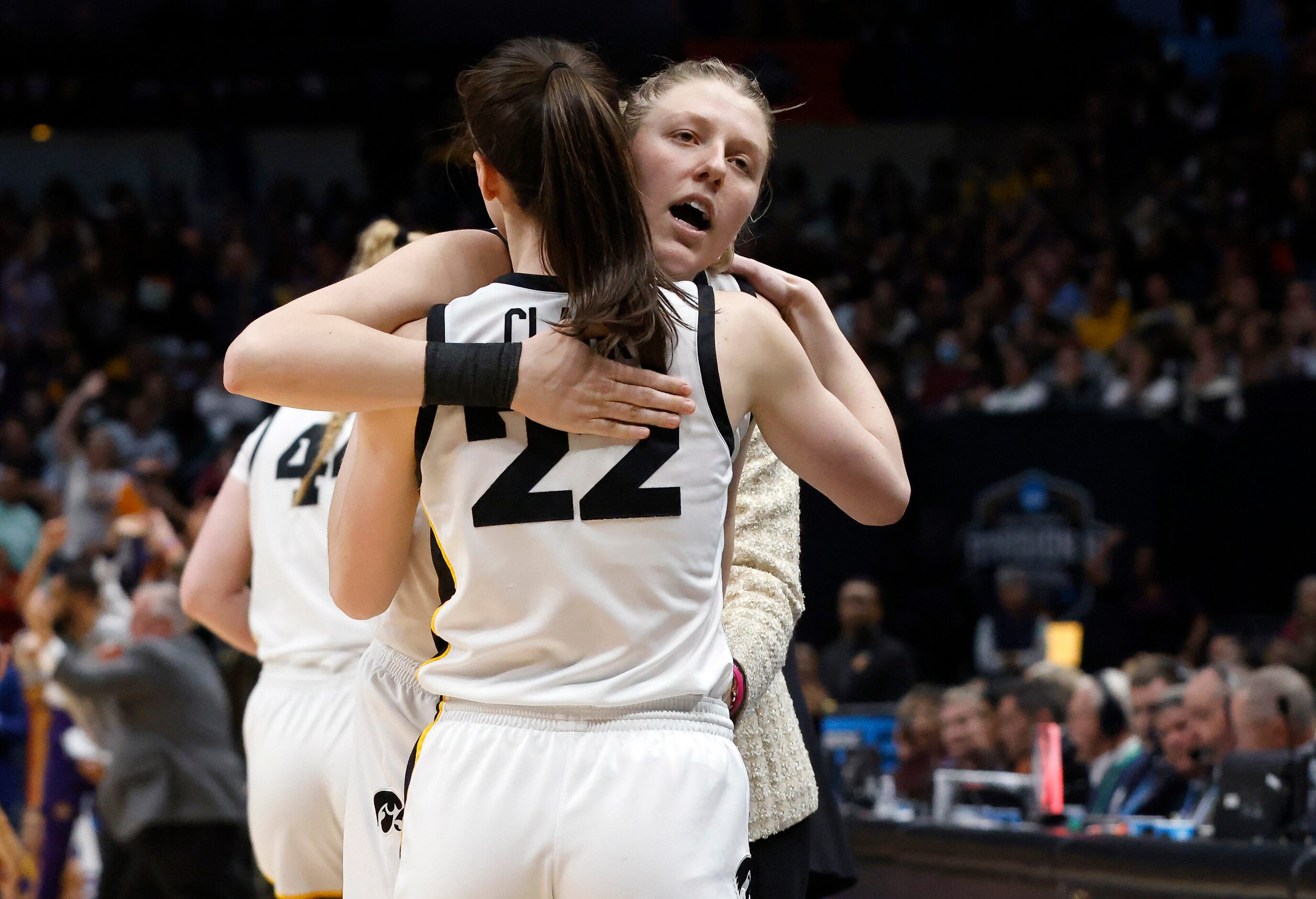 Iowa Hawkeyes guard Caitlin Clark (22) gives forward Monika Czinano (25), who fouled out of...