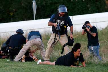 Dallas police Sgt. Roger Rudloff stands over Jantzen Verastique (center) after shooting her...