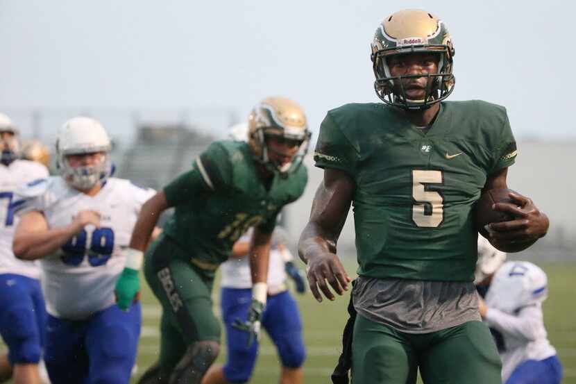 DeSoto quarterback Tristen Wallace rushes for a touchdown in the first quarter to make the...