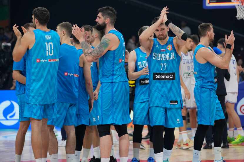 Slovenia guard Luka Doncic (77) and teammates clap after winning against Italy during the...