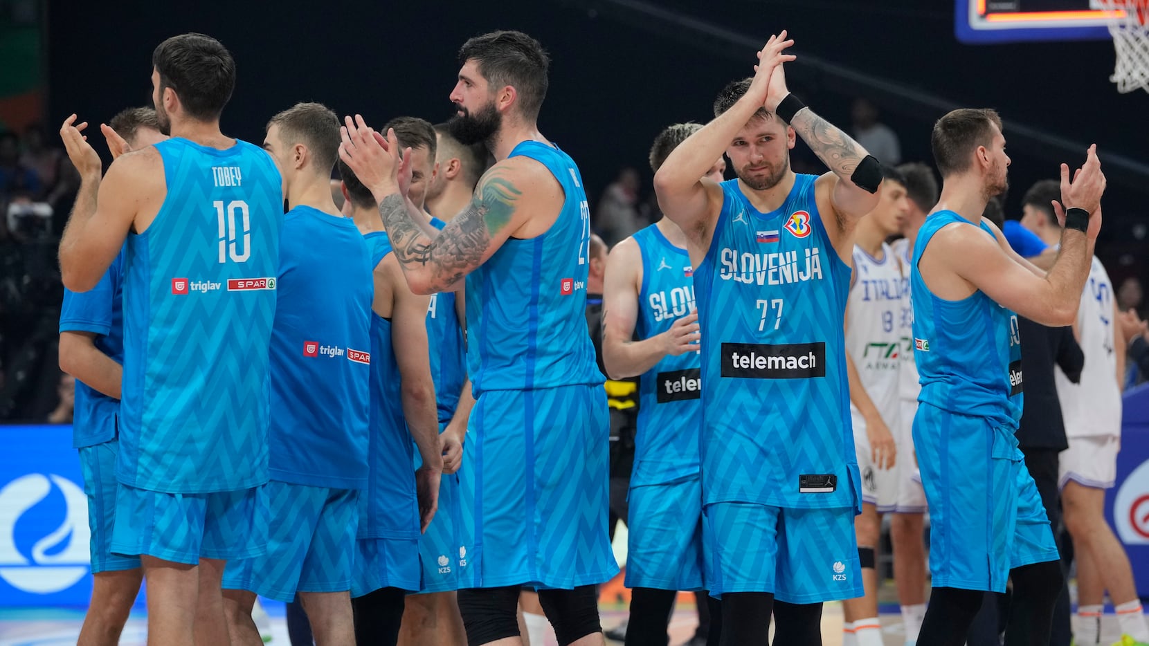 Slovenia guard Luka Doncic (77) and teammates clap after winning against Italy during the...