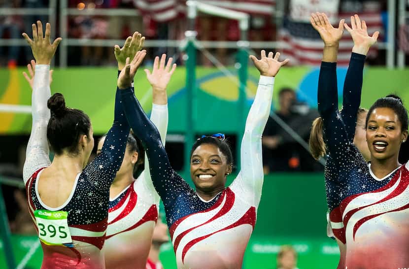 Simone Biles of the United States (center) waves to the crowd with her teammates (from left)...