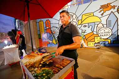 Abdon Corral of Austin cooks Mexican hot dogs in front of the American Airlines Center,...