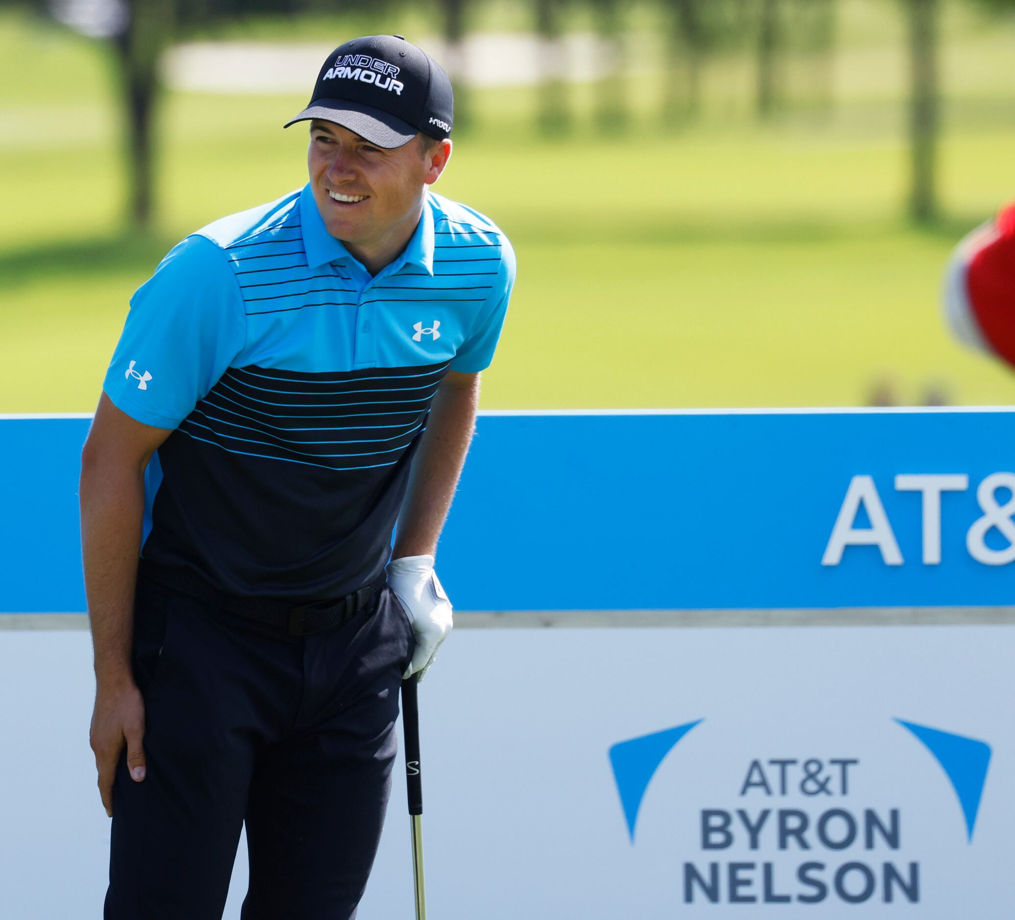 Jordan Spieth smiles after teeing off on the 15th hole during round 1 of the AT&T Byron...