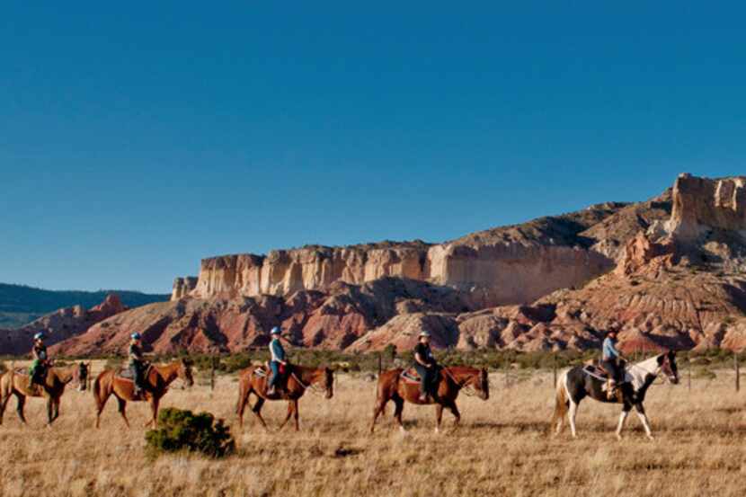 Horseback riders hit the trail at Ghost Ranch, the former summer home of artist Georgia...