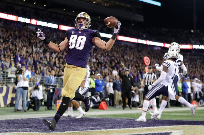 FILE - Washington tight end Drew Sample, left, runs for a touchdown after a pass reception...