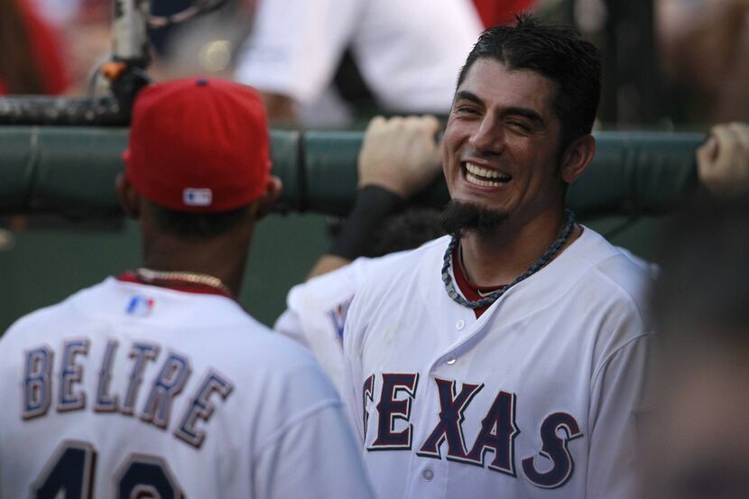 Rangers starter Matt Garza jokes with center fielder Engel Beltre in the dugout at Rangers...