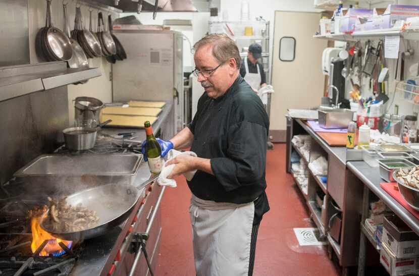 Chef Gerard Rousset sautes mushrooms at the Italian Club of Dallas. He is trained in French...