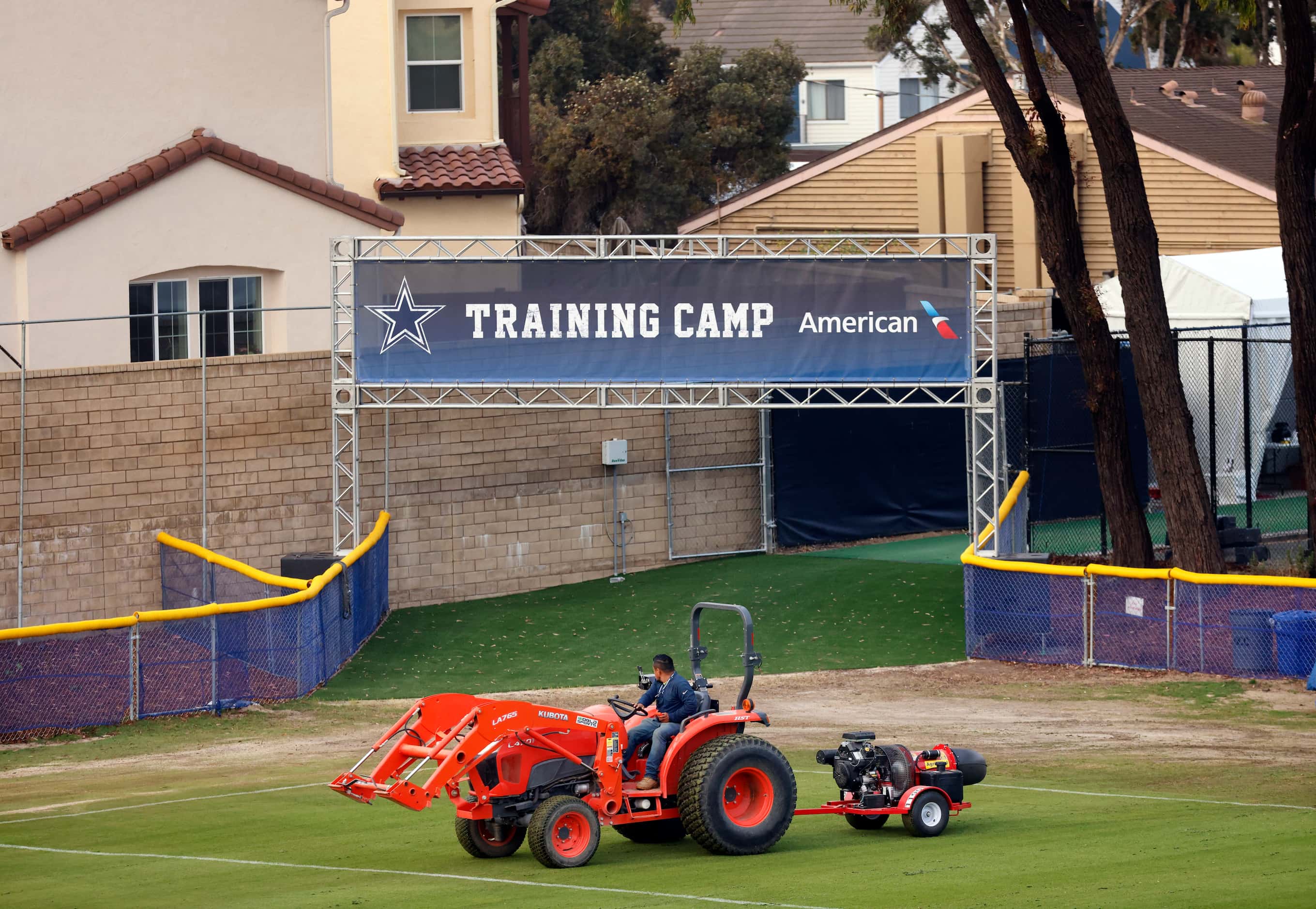 A grounds crewman blows freshly cut grass clippings from the field in preparation for the...