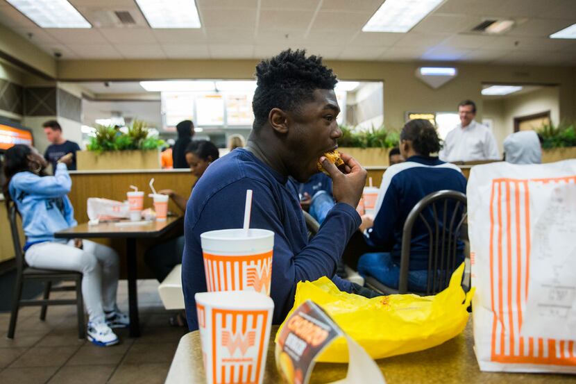 Lone Star High School football player Darrin Smith, 16, takes a bite of his triple burger...