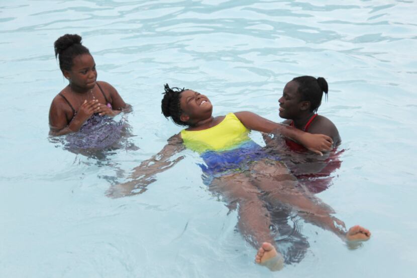 A’Ronica Rollins teaches Jhada Toney, 8, how to float on her back while Malysse Robinson, 8,...