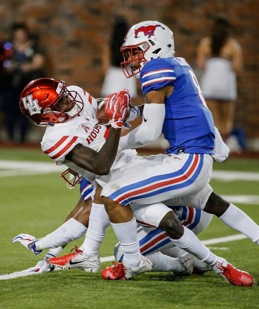 SMU defensive back Rodney Clemons, right, tackles Houston wide receiver Marquez Stevenson...