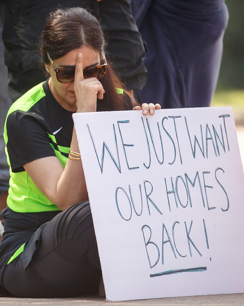 Cinco Ranch Canyon Gate subdivision resident Pia Anand holds her head as she joins...