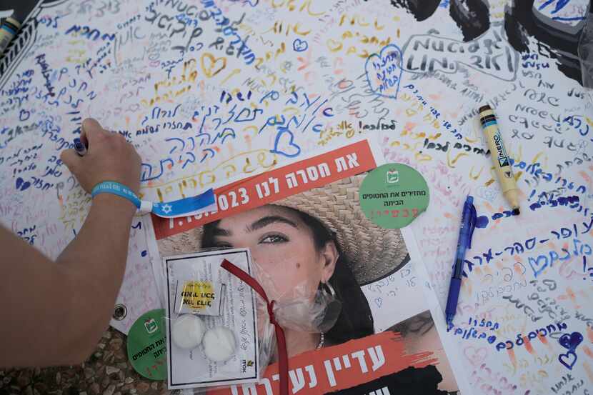 A person writes a message while participating in a show of solidarity with hostages being...